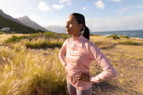 Woman enjoying outdoor workout in nature, standing confidently with hands on hips. Fitness, exercise, wellness, confidence, empowerment, outdoors