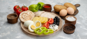 1788775718_front_view_boiled_eggs_with_olives_breasts_tomatoes_light_desk_vegetable_food_meal